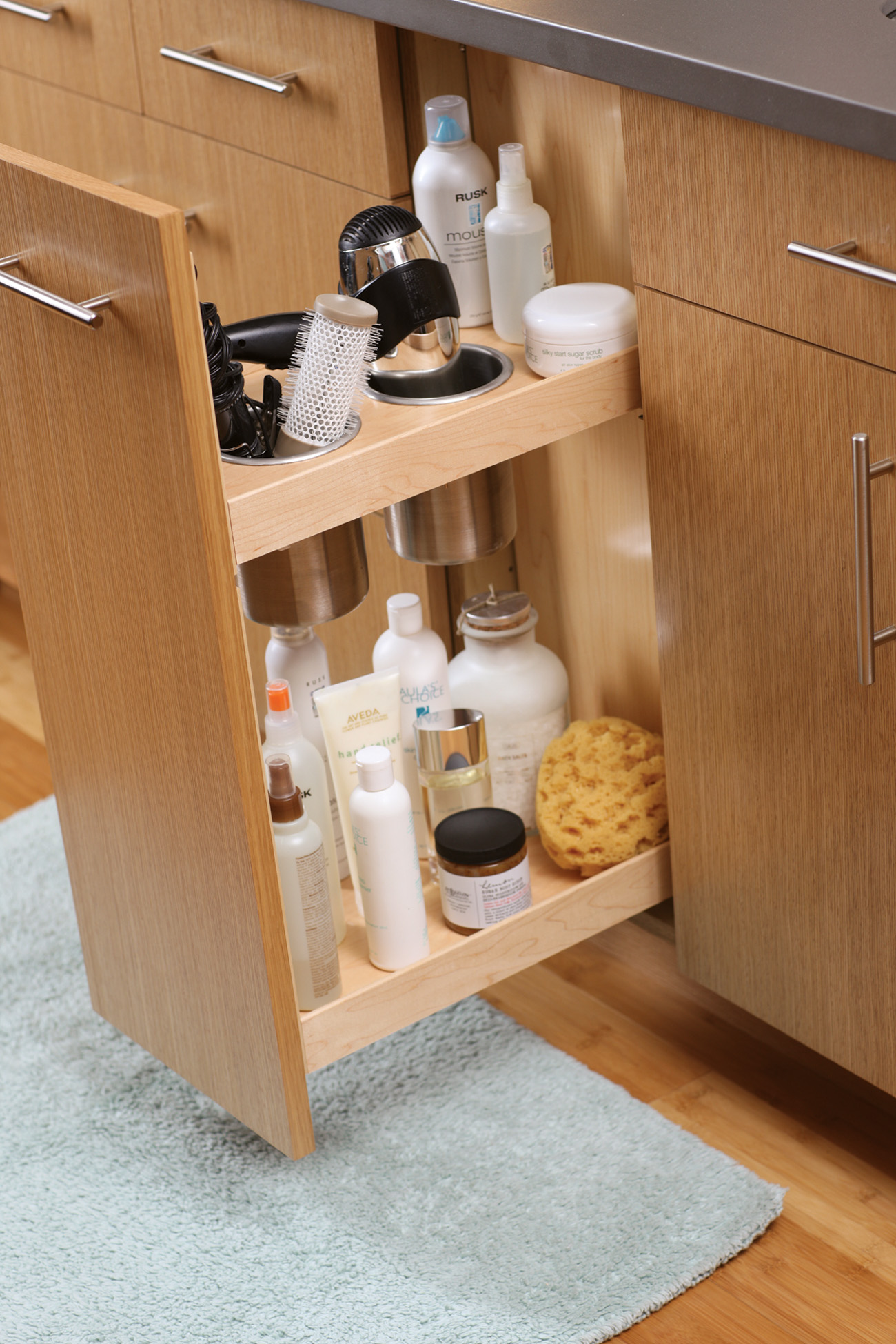 Organized pull-out storage for beauty products, curling irons, hair dryers, etc. in the bathroom with a Vanity Grooming Cabinet accessory.